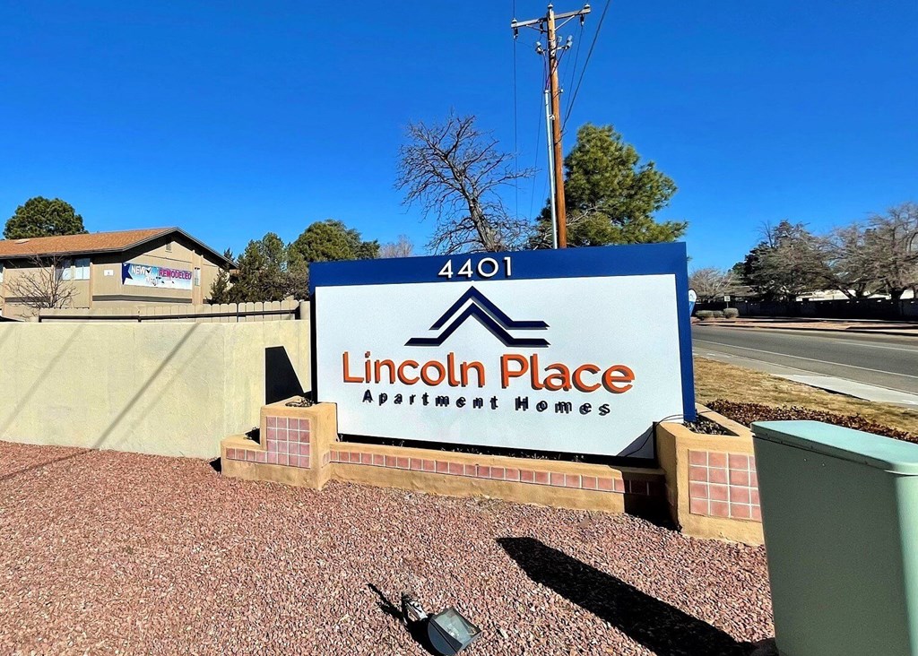A sign for Lincoln Place Apartment Homes is displayed in front of a building.